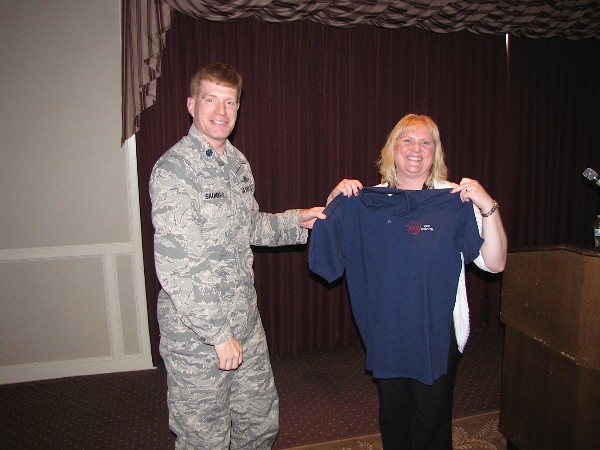 Lt. Col. Arnold Saunders, USAF, chapter president, presents a chapter shirt to the September luncheon speaker, Helen Davis, special projects team lead, Enterprise Services Center.